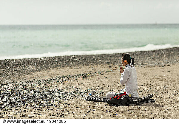 A woman prays on a beach in South Korea.
