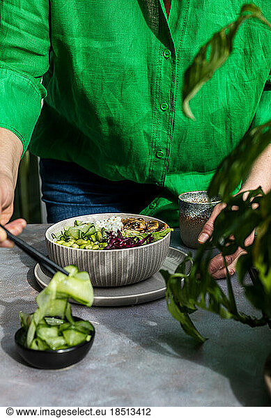 A woman prepares a green bowl Vegetarian or vegan food concept.