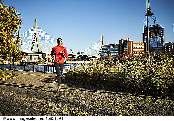 A woman running in front of the Zakim Bridge in Boston.