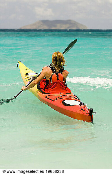 A woman sea kayaking in tropical water in Virgin Islands National Park  St. John.
