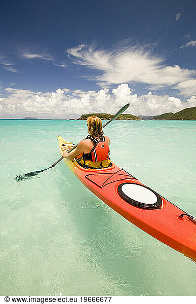 A woman sea kayaking in tropical waters at St. John  Virgin Islands National Park.