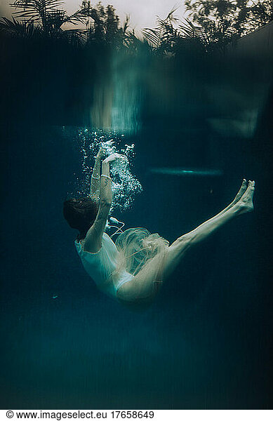 A woman sinking to the bottom of a pool