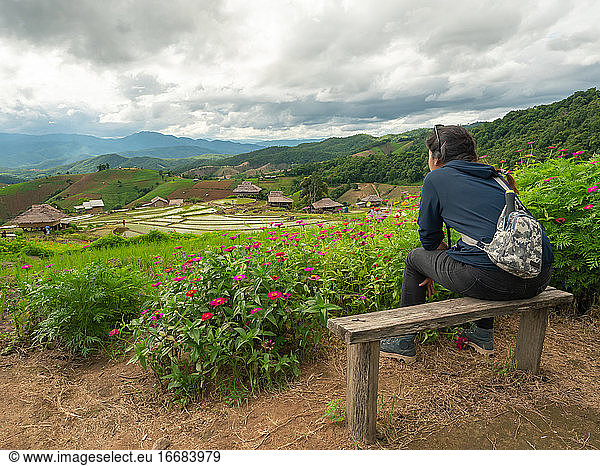 A woman sitting and watching the rice terraces.