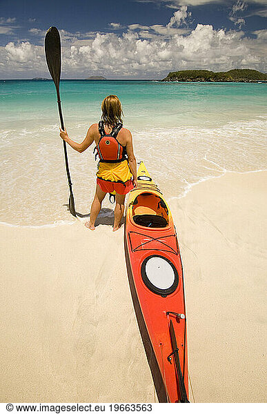 A woman standing with her sea kayak in Virgin Islands National Park  St. John.