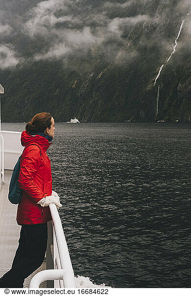 A woman stares at the natural beauty Milford Sound  New Zealand.