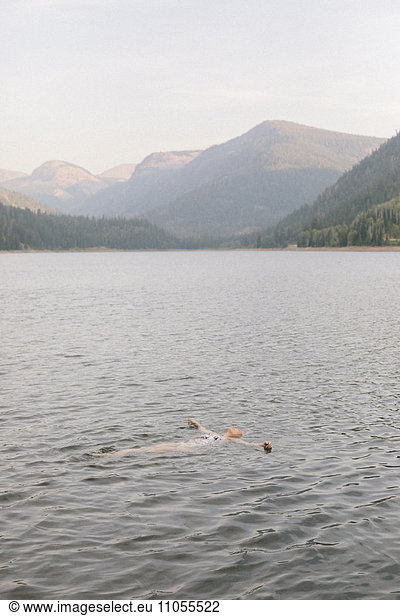 A woman swimming in the waters of a lake.
