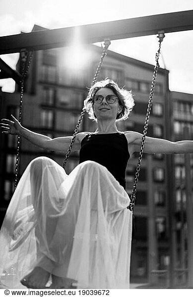 A woman swings on a swing  summer atmosphere.