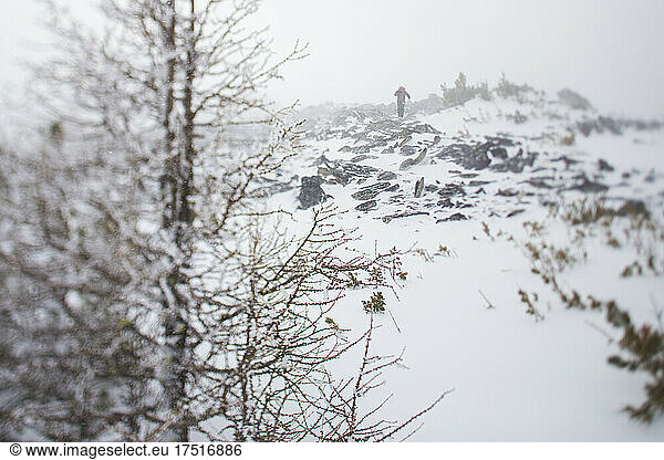 A woman walks on the top of rocky summit in harsh weather