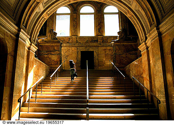A woman walks up the stairs inside the Boston Public Library in Boston  Massachusetts.