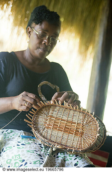 A woman weaves a traditional basket in the Touna Kalinago Heritage Village in the Kalinago Territory on the Caribbean island of Dominica.