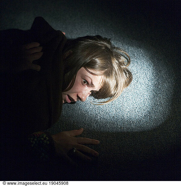 A woman with her face against the floor.
