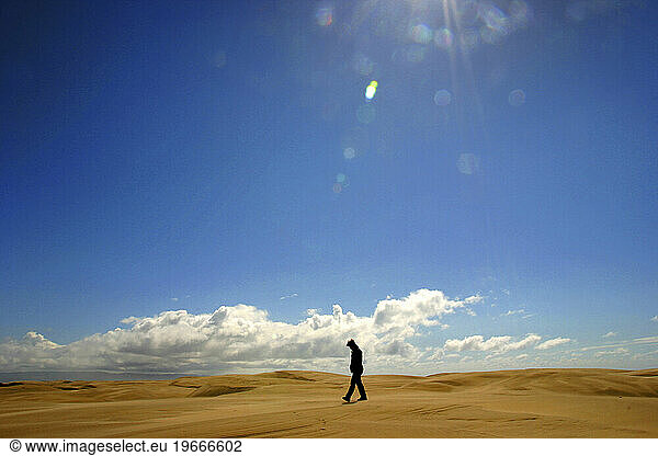 A women walks alone though the Pismo Beach sand dunes. Pismo Beach  California.
