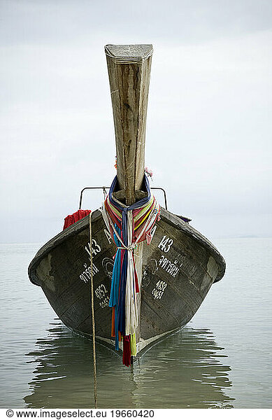 A wooden boat anchored off shore