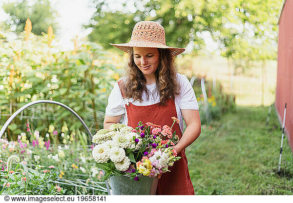 A 30 year old woman looking at her bouquet of freshly cut flower