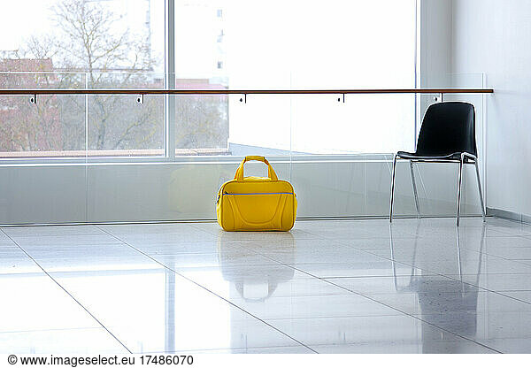 A yellow bag in a light and airy empty corridor Yellow bag.