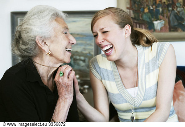 A young and an elderly woman laughing