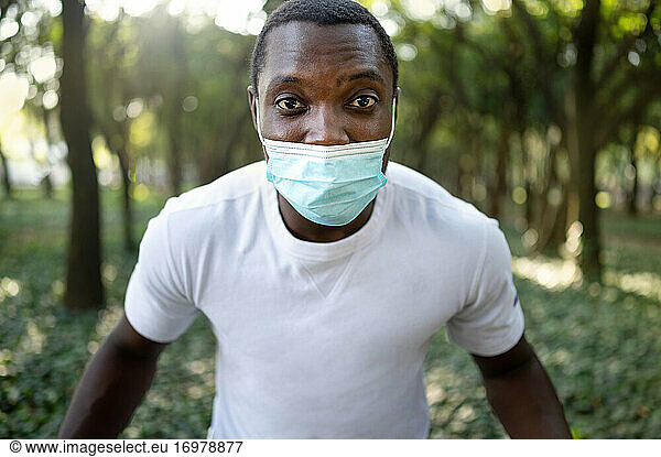 A young black man with a mask in the covid-19 pandemic season.
