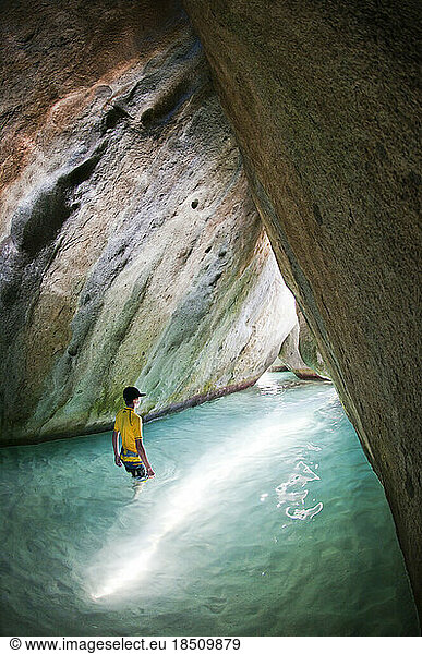 A young boy explores tropical cave.