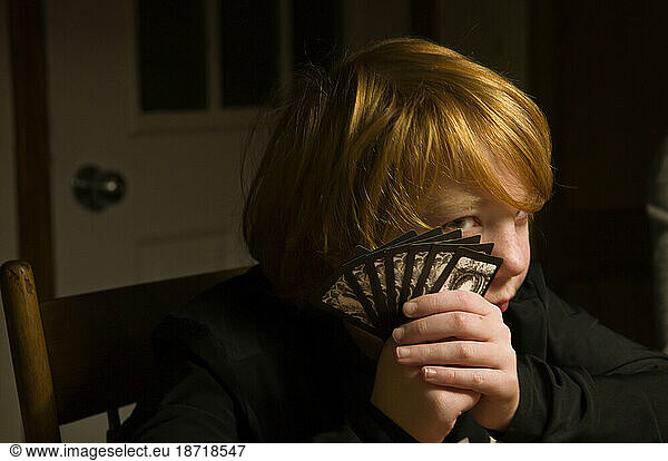 A young boy holds playing cards up to his face during a family holiday gathering in Richfield  Minnesota.
