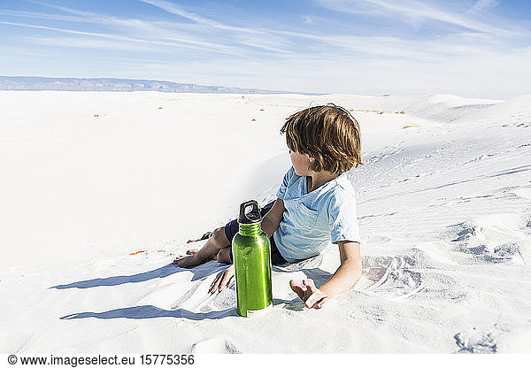 A young boy with green water bottle