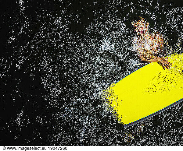A Young Boy With His Face Submerged In The Water While Holding On To A Flotation Device In The Russian River
