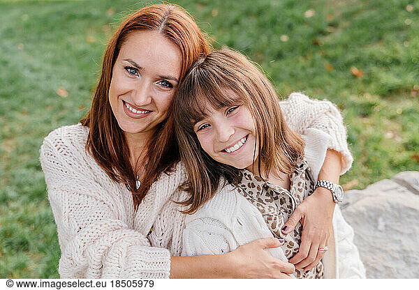 A young caucasian woman with red hair and a teenage daughter are