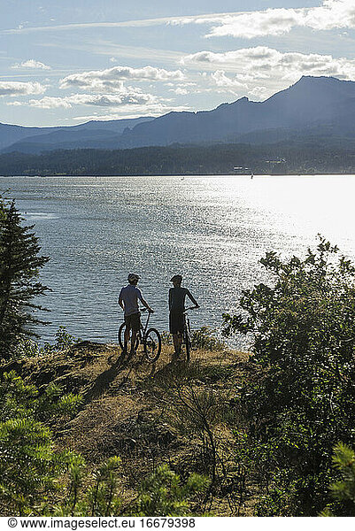 A young couple enjoy a view of the Columbia River while biking in OR.