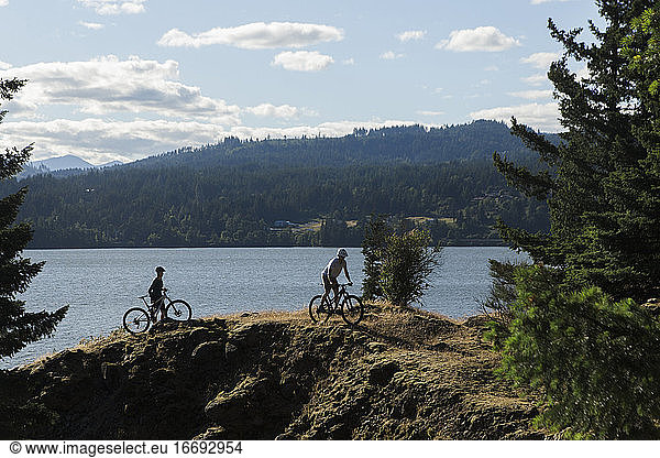 A young couple enjoy a view of the Columbia River while biking in OR.