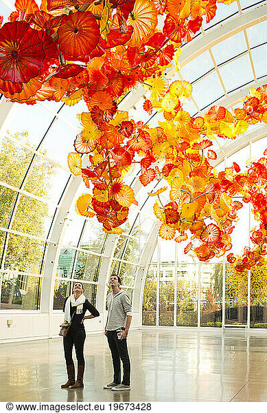 A young couple enjoy the glass installation at the Chihuly's exhibit in the Seattle Center  Seattle  WA.