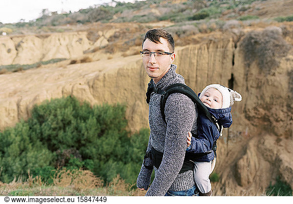 A young father babywearing his son during a hike in Southern Cali.