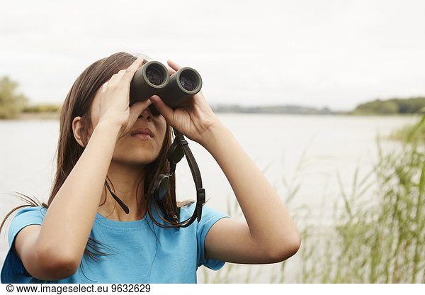 A young girl  a birdwatcher with binoculars.