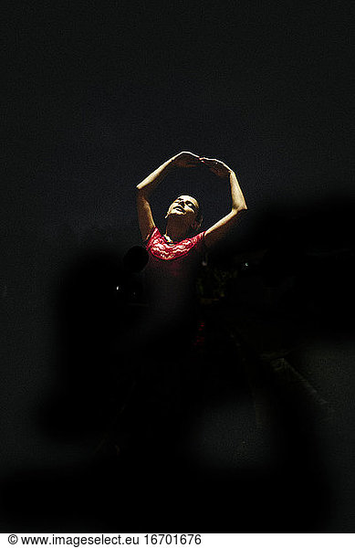 A young girl doing ballet under a street lamp