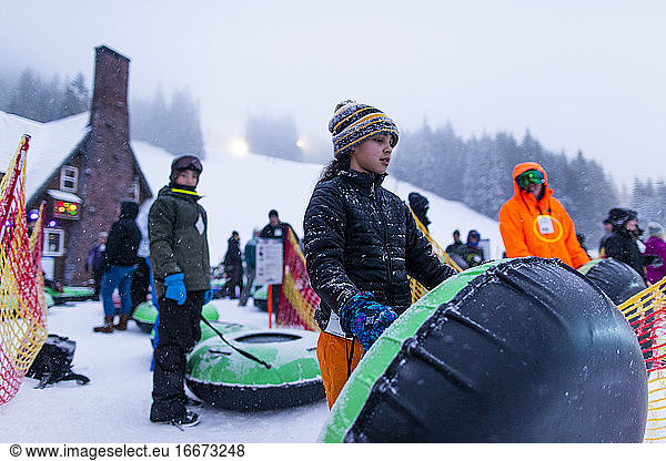 A young girl gets ready to go tubing down a hill in Oregon.