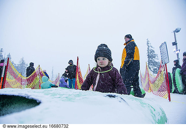 A young girl gets ready to ride a tube down the snow hill in Oregon.