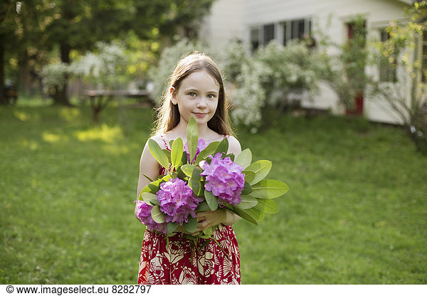 A Young Girl Holding A Bunch Of Purple Hydrangea Flowerheads.
