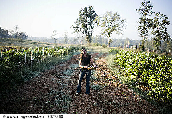 A young girl holds a basket of vegetables at an organic farm outside Atlanta  GA.