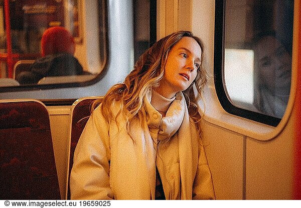 A young girl rides by the window in a subway train