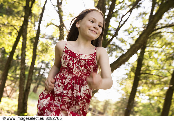 A Young Girl Running Along Through Trees On A Farm.