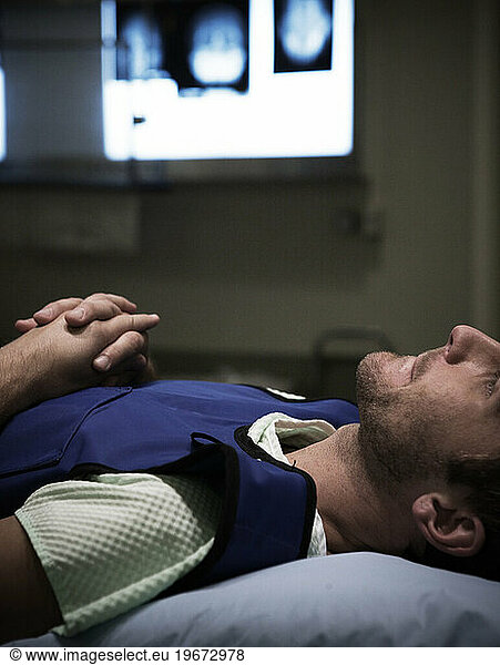 A young man lying down on a hospital table.