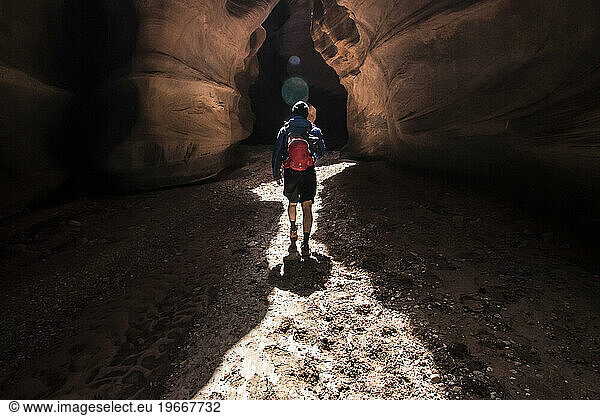 A Young Man Prepares To Leave Behind The Sun As He Enters The Long Narrows Of Buckskin Gulch