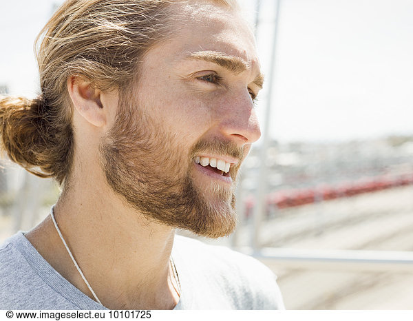 A young man with beard  red hair and ponytail.