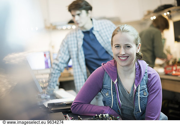 A young woman and man  staff in a computer repair shop.