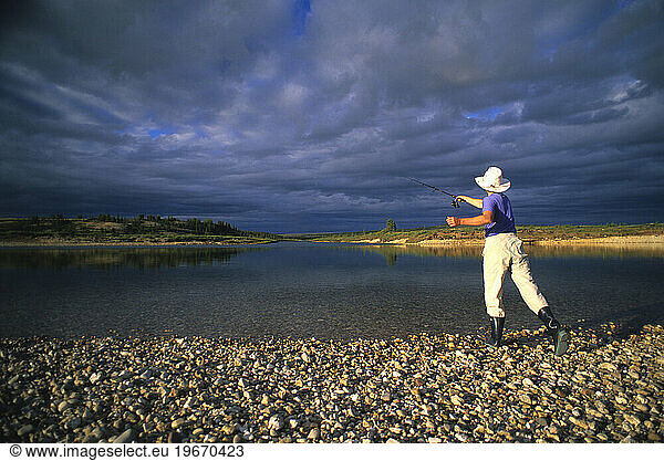 A young woman casts at the junction of the Horton River and the Whaleman River in Canada's Northwest Territories.