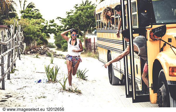 A young woman chasing after a moving school bus.