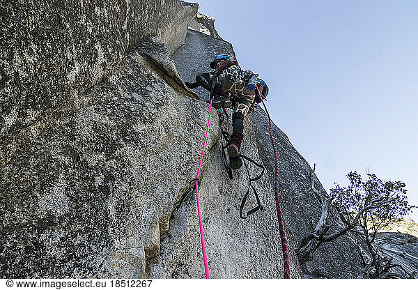A young woman climber sets out on her first aid climbing lead