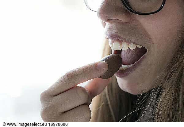 a young woman eats chocolate