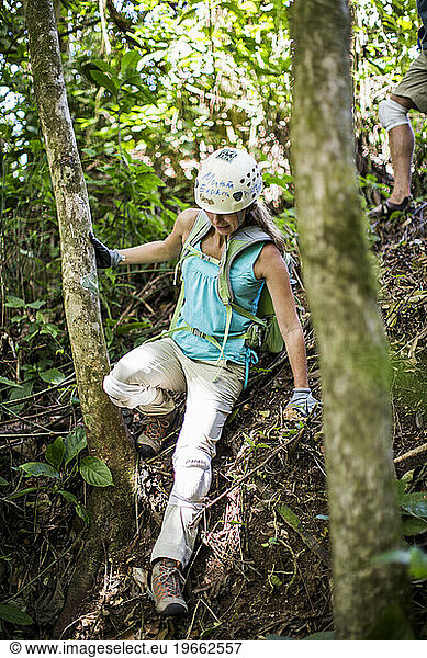 A young woman hikes through the jungles of Puerto Rico on an adventure on a sunny day.