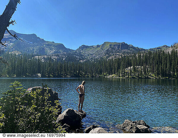 A young woman prepares to jump into an alpine lake in Montana.