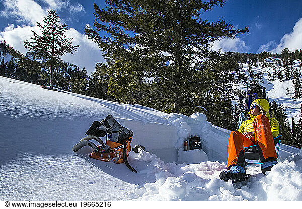 A Young Woman Relaxing After Ski Touring And Digging Avalanche Pits