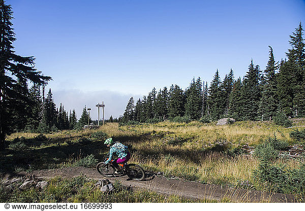 A young woman rides her bike on a sunny day at Mt. Hood  Oregon.